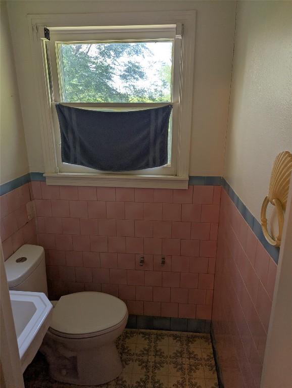 606 Scurry St, Austin, TX 78753 - bathroom featuring tile walls and a wainscoted wall