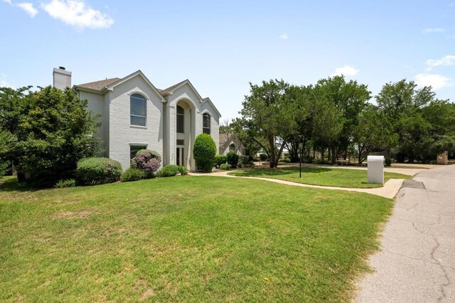 707 Malabar St, Lakeway, TX 78734 - view of front of home with a front yard and a chimney
