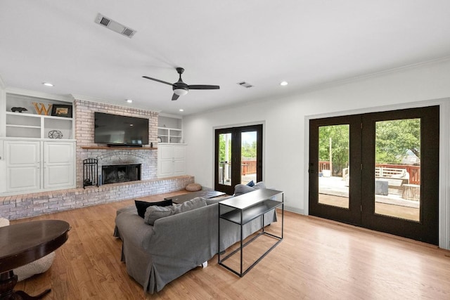 707 Malabar St, Lakeway, TX 78734 - living area with french doors, light wood-style floors, ornamental molding, built in features, and a fireplace
