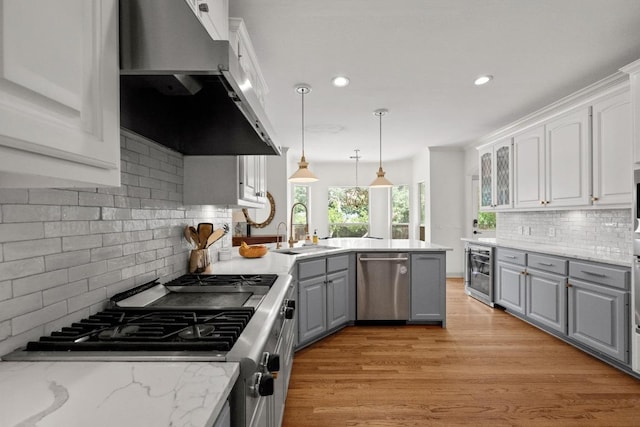 707 Malabar St, Lakeway, TX 78734 - kitchen with stainless steel dishwasher, gray cabinets, range, exhaust hood, and wine cooler