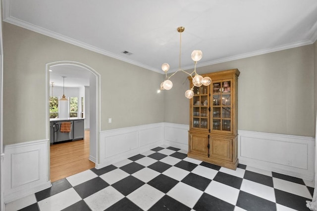 707 Malabar St, Lakeway, TX 78734 - dining area with arched walkways, tile patterned floors, a wainscoted wall, and crown molding