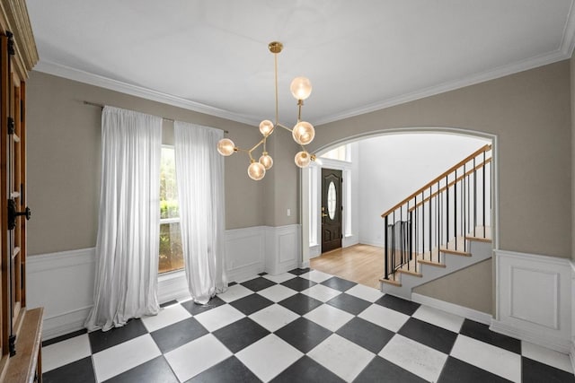 707 Malabar St, Lakeway, TX 78734 - entrance foyer with arched walkways, tile patterned floors, wainscoting, ornamental molding, and a chandelier