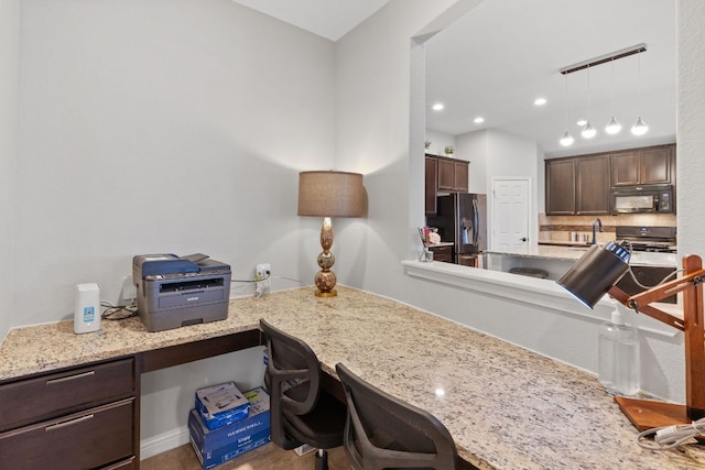 1700 Elaina Loop, Leander, TX 78641 - kitchen with black microwave, stainless steel refrigerator with ice dispenser, dark brown cabinets, stove, and built in study area