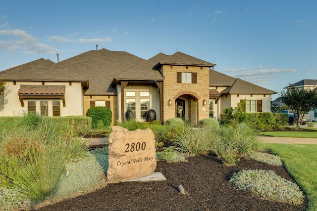 2800 Crystal Falls Pkwy, Leander, TX 78641 - french country inspired facade featuring stone siding, a shingled roof, and stucco siding
