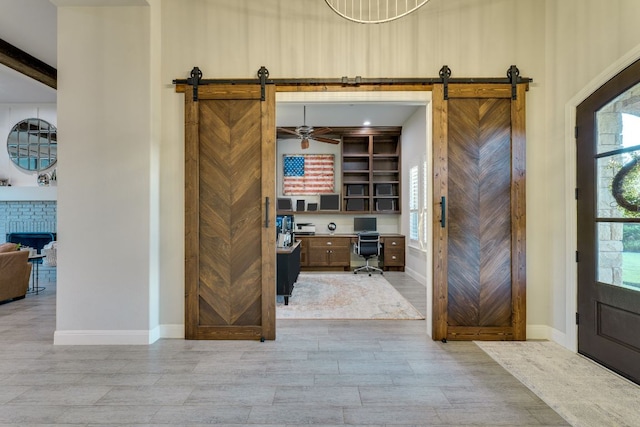 2800 Crystal Falls Pkwy, Leander, TX 78641 - foyer with a barn door, built in desk, a brick fireplace, and wood finished floors