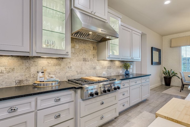 2800 Crystal Falls Pkwy, Leander, TX 78641 - kitchen with under cabinet range hood, stainless steel gas cooktop, tasteful backsplash, and dark countertops