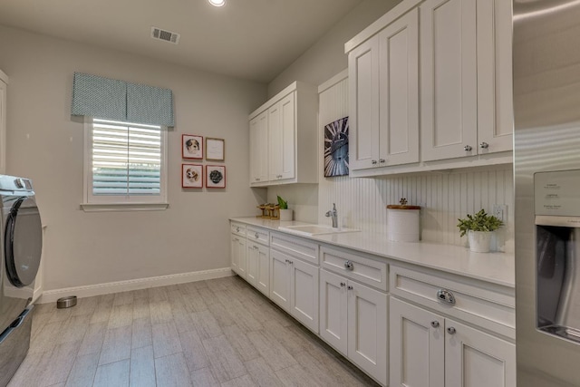 2800 Crystal Falls Pkwy, Leander, TX 78641 - laundry room with cabinet space, washer / dryer, and light wood-style flooring