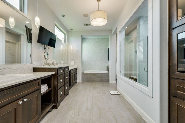 2800 Crystal Falls Pkwy, Leander, TX 78641 - full bathroom featuring vanity, a garden tub, a stall shower, and wood finished floors