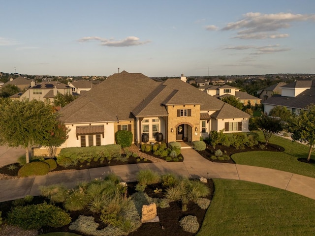 2800 Crystal Falls Pkwy, Leander, TX 78641 - french country style house featuring a front lawn, a residential view, stucco siding, and roof with shingles