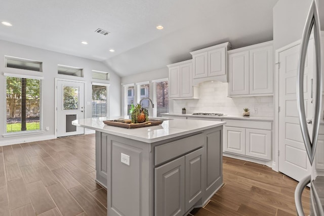 3604 Mercer Rd, Georgetown, TX 78628 - kitchen featuring gray cabinetry, light countertops, wood finished floors, lofted ceiling, and a kitchen island with sink