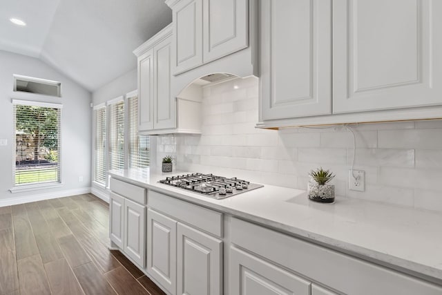 3604 Mercer Rd, Georgetown, TX 78628 - kitchen featuring stainless steel gas cooktop, lofted ceiling, white cabinetry, and backsplash