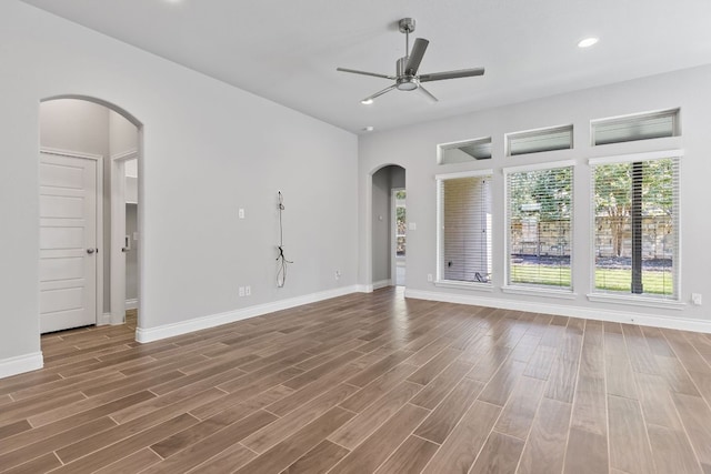 3604 Mercer Rd, Georgetown, TX 78628 - unfurnished living room with arched walkways, a ceiling fan, wood finished floors, and recessed lighting