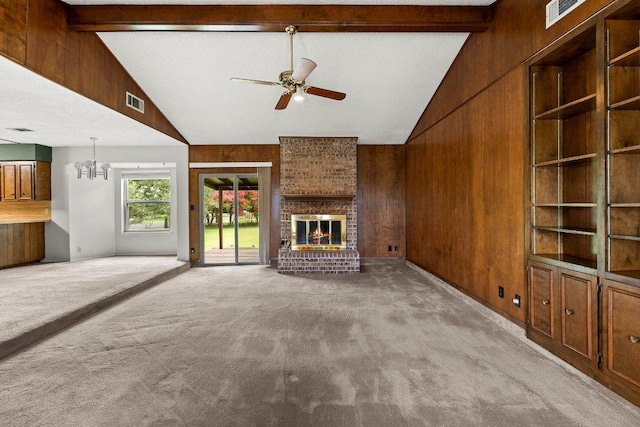 2403 N Shields Dr, Austin, TX 78727 - unfurnished living room featuring light colored carpet, wood walls, ceiling fan, a fireplace, and a chandelier