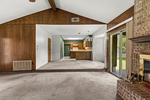 2403 N Shields Dr, Austin, TX 78727 - unfurnished living room with a brick fireplace, carpet floors, and wood walls