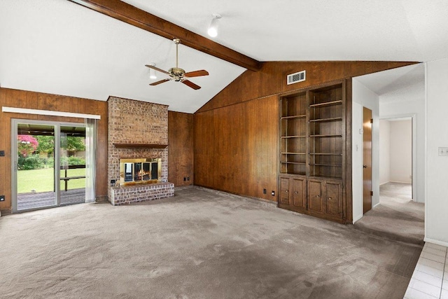 2403 N Shields Dr, Austin, TX 78727 - unfurnished living room with wood walls, a ceiling fan, carpet floors, and a brick fireplace