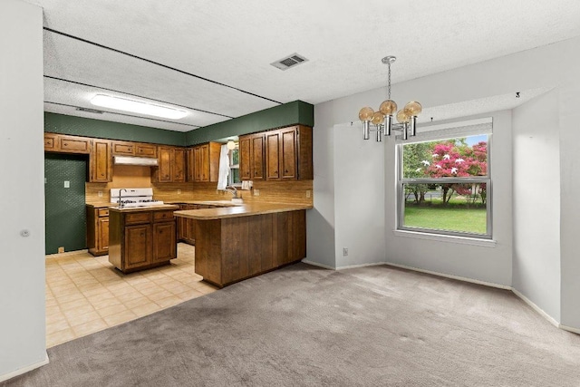 2403 N Shields Dr, Austin, TX 78727 - kitchen featuring a chandelier, under cabinet range hood, light carpet, white range oven, and brown cabinetry