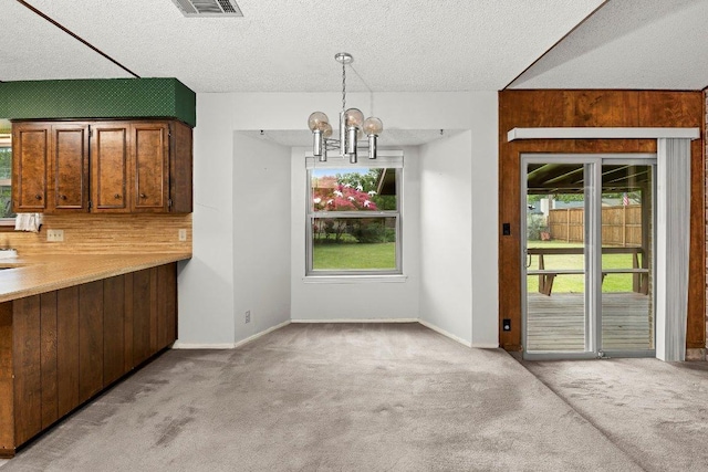 2403 N Shields Dr, Austin, TX 78727 - unfurnished dining area with carpet, a chandelier, and a textured ceiling