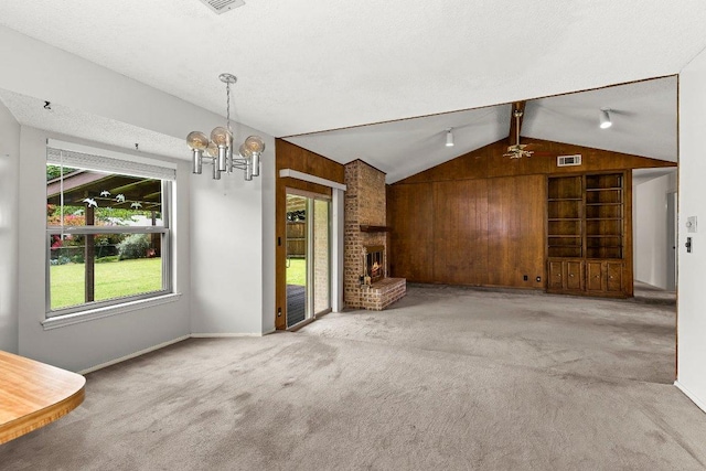 2403 N Shields Dr, Austin, TX 78727 - unfurnished living room with lofted ceiling, carpet, plenty of natural light, a chandelier, and a fireplace