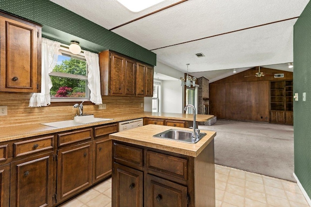 2403 N Shields Dr, Austin, TX 78727 - kitchen with open floor plan, lofted ceiling, a kitchen island with sink, a chandelier, and light colored carpet