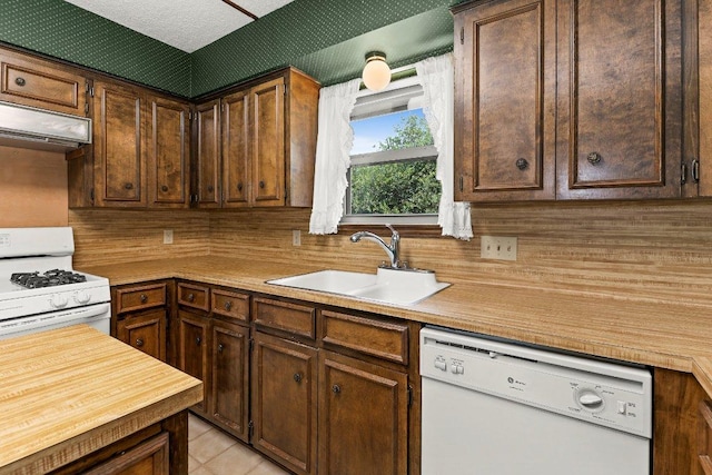 2403 N Shields Dr, Austin, TX 78727 - kitchen featuring white appliances, exhaust hood, tasteful backsplash, and dark brown cabinets