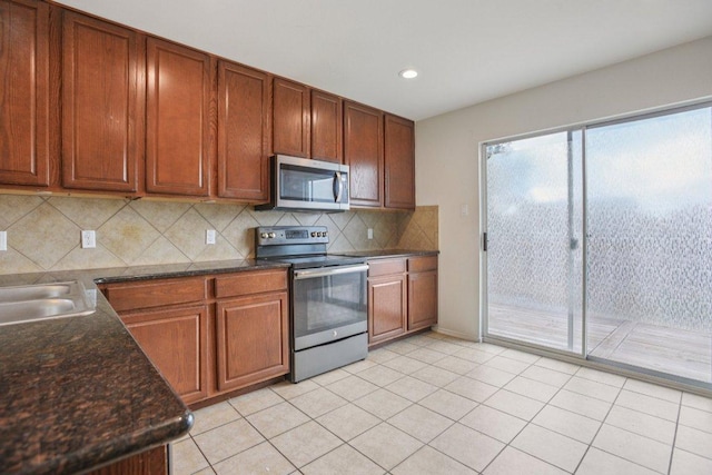 13413 Lismore Ln, Pflugerville, TX 78660 - kitchen with stainless steel appliances, backsplash, recessed lighting, light tile patterned floors, and brown cabinetry