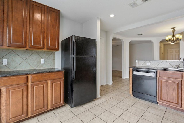 13413 Lismore Ln, Pflugerville, TX 78660 - kitchen featuring black appliances, arched walkways, a chandelier, light tile patterned floors, and backsplash