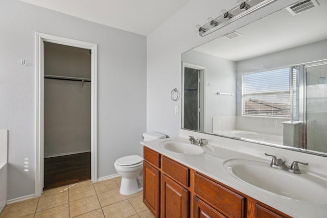 13413 Lismore Ln, Pflugerville, TX 78660 - bathroom featuring a walk in closet, a garden tub, double vanity, tile patterned flooring, and an enclosed shower