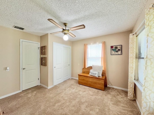 702 Pleasant Grove Rd, Elgin, TX 78621 - carpeted bedroom with a ceiling fan, a textured ceiling, and a closet