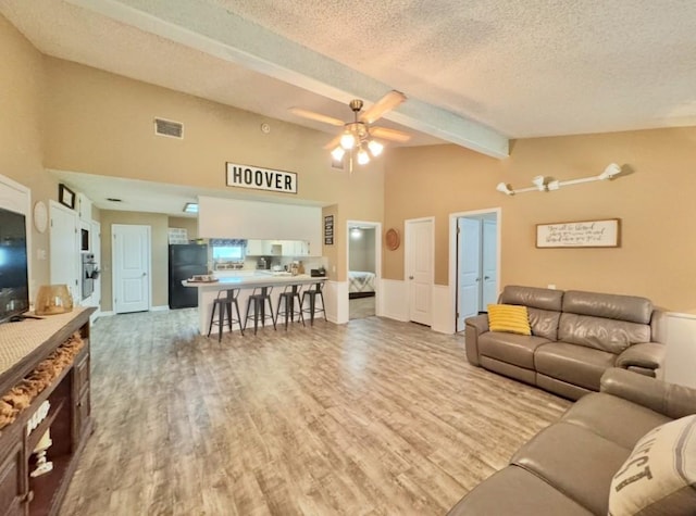 702 Pleasant Grove Rd, Elgin, TX 78621 - living area with beam ceiling, a textured ceiling, wood finished floors, a ceiling fan, and high vaulted ceiling