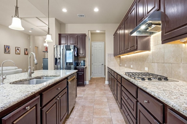 14405 Laurinburg Dr, Austin, TX 78717 - kitchen with under cabinet range hood, appliances with stainless steel finishes, tasteful backsplash, pendant lighting, and dark brown cabinetry