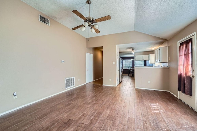 14305 Vandever St, Austin, TX 78725 - unfurnished living room with lofted ceiling, a textured ceiling, a ceiling fan, and wood finished floors