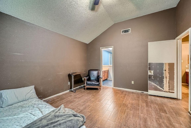 14305 Vandever St, Austin, TX 78725 - sitting room with wood finished floors, vaulted ceiling, and a textured ceiling
