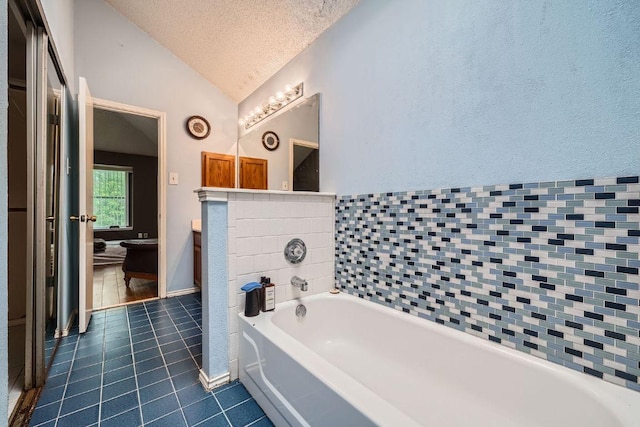 14305 Vandever St, Austin, TX 78725 - full bathroom with lofted ceiling, tile patterned flooring, a textured ceiling, a bath, and vanity