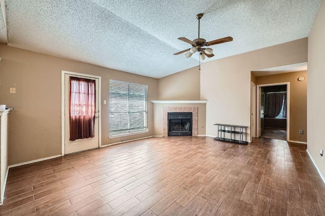 14305 Vandever St, Austin, TX 78725 - unfurnished living room with a textured ceiling, a ceiling fan, wood finished floors, and a fireplace