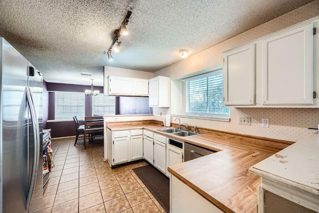 14305 Vandever St, Austin, TX 78725 - kitchen featuring stainless steel appliances, a peninsula, light countertops, and a textured ceiling