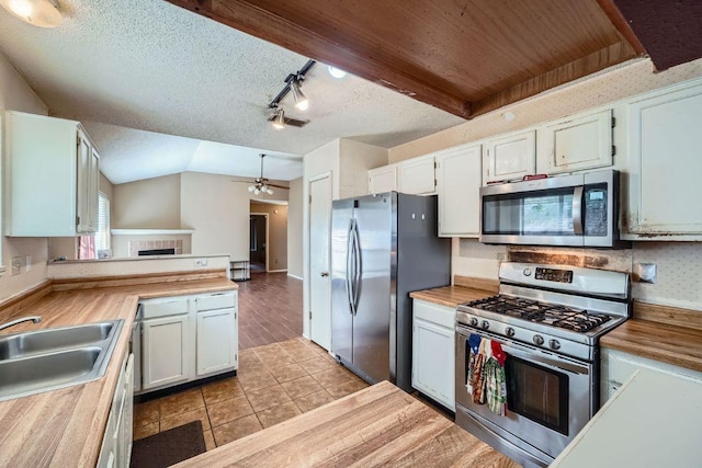 14305 Vandever St, Austin, TX 78725 - kitchen featuring stainless steel appliances, track lighting, ceiling fan, tile patterned floors, and butcher block countertops