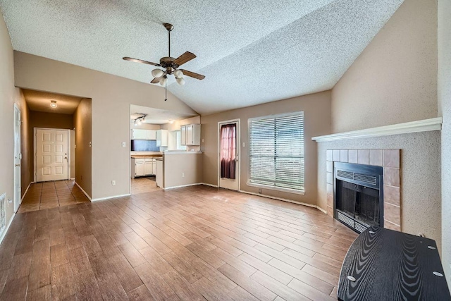 14305 Vandever St, Austin, TX 78725 - unfurnished living room with vaulted ceiling, heating unit, a ceiling fan, wood finished floors, and a textured ceiling
