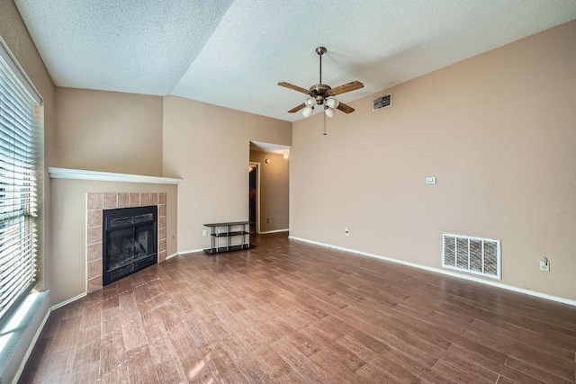 14305 Vandever St, Austin, TX 78725 - unfurnished living room featuring a ceiling fan, wood finished floors, a textured ceiling, and a tile fireplace