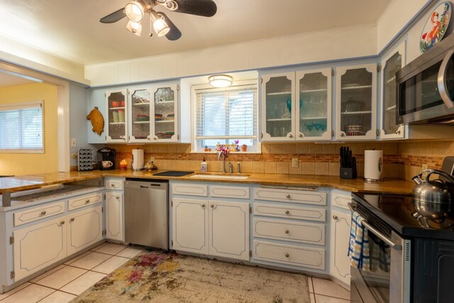507 Flamingo Cir, Marble Falls, TX 78654 - kitchen with appliances with stainless steel finishes, light tile patterned floors, plenty of natural light, a ceiling fan, and ornamental molding