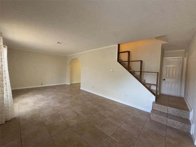 4503 E Stassney Ln, Austin, TX 78744 - tiled spare room featuring a textured ceiling, stairs, arched walkways, and ornamental molding