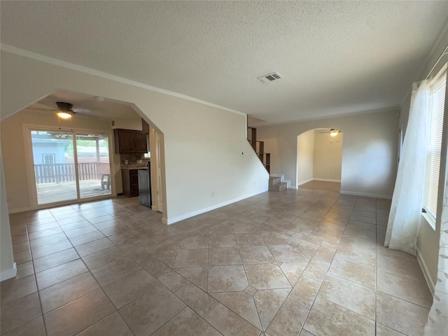 4503 E Stassney Ln, Austin, TX 78744 - empty room with arched walkways, a ceiling fan, light tile patterned flooring, stairway, and a textured ceiling