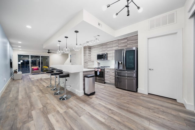 604 N Bluff Dr Unit 247, Austin, TX 78745 - kitchen with appliances with stainless steel finishes, modern cabinets, a kitchen breakfast bar, light countertops, and a chandelier