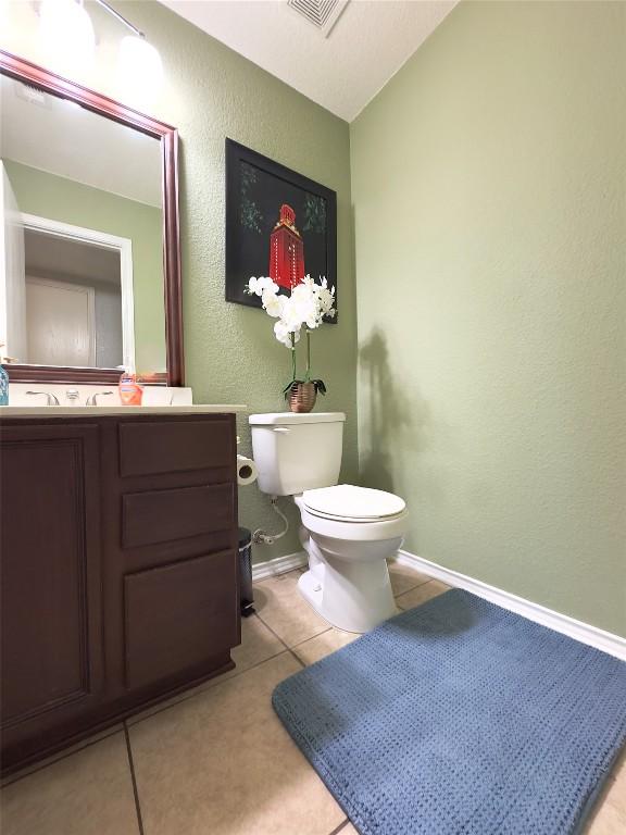 551 Abundance Ln, Kyle, TX 78640 - bathroom featuring vanity, tile patterned flooring, a textured wall, and lofted ceiling