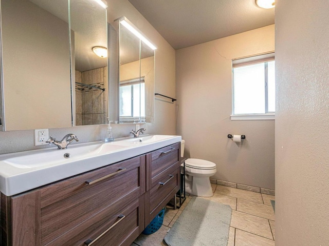 6801 Bryn Mawr Dr, Austin, TX 78723 - bathroom with double vanity, healthy amount of natural light, a tile shower, and tile patterned flooring