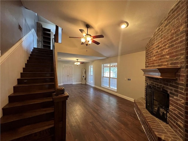 2120 Fm 1704, Elgin, TX 78621 - unfurnished living room featuring a ceiling fan, a fireplace, stairs, dark wood-type flooring, and vaulted ceiling