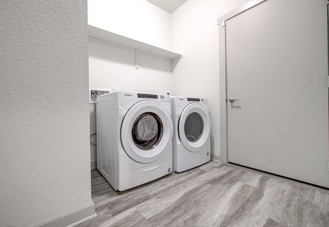 261 Deserti Rd, Leander, TX 78641 - laundry area featuring light wood-style flooring, washer and clothes dryer, and a textured wall
