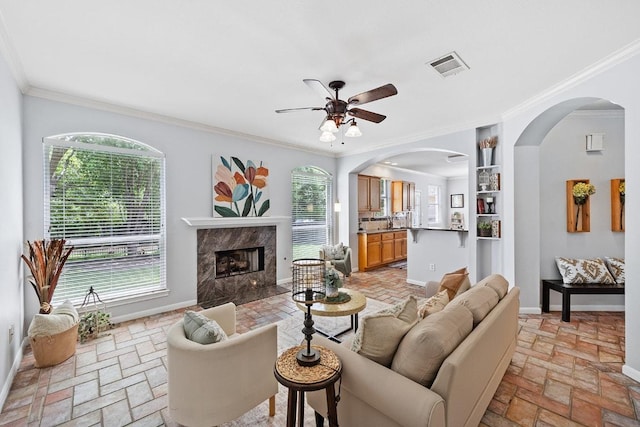 15213 Mallard Green Ln, Austin, TX 78728 - living area with ornamental molding, a ceiling fan, arched walkways, and a high end fireplace