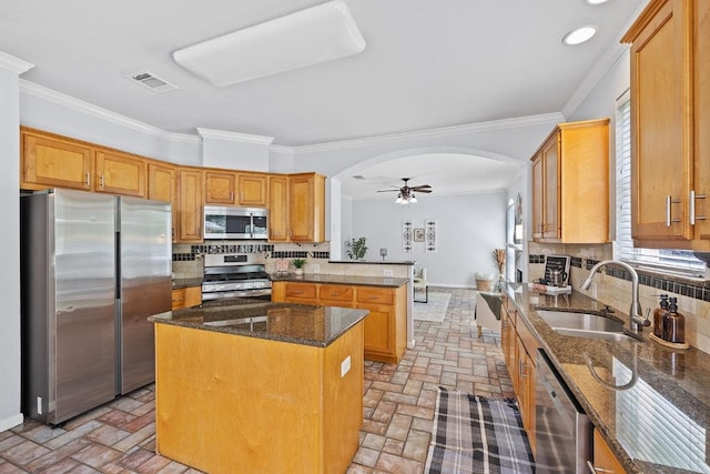 15213 Mallard Green Ln, Austin, TX 78728 - kitchen with stainless steel appliances, arched walkways, brick flooring, backsplash, and ornamental molding