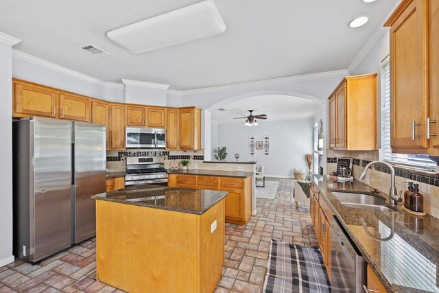 15213 Mallard Green Ln, Austin, TX 78728 - kitchen with stainless steel appliances, arched walkways, brick flooring, backsplash, and ornamental molding