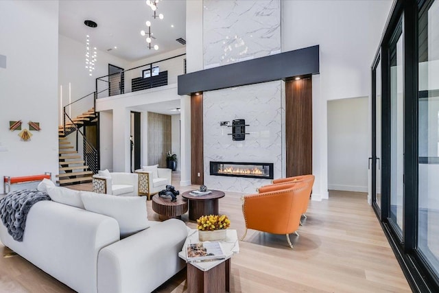 1806 Lauren Dr, Spicewood, TX 78669 - living area with a high ceiling, wood finished floors, stairway, and a premium fireplace